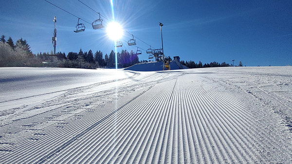 Sonniger Blick auf die Piste und den Lift